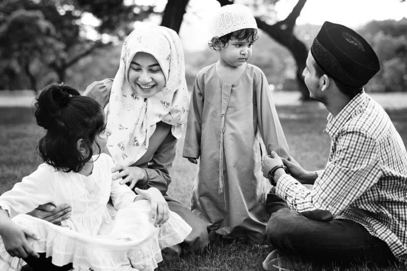 Sebuah keluarga terdiri dari ayah, ibu, dan seorang anak laki-laki serta perempuan sedang menghabiskan waktu di sebuah taman